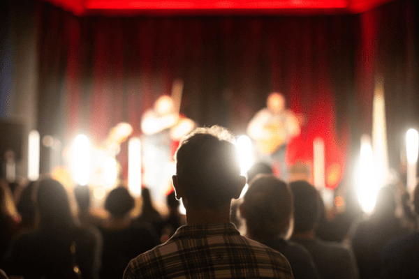 A crowd of people watch a band on stage.