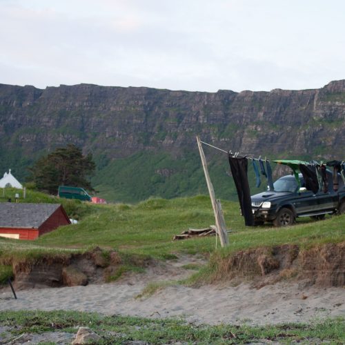 The Isle of Eigg. A line of washing can be seen hanging near the shore. A house can be seen in the distance.